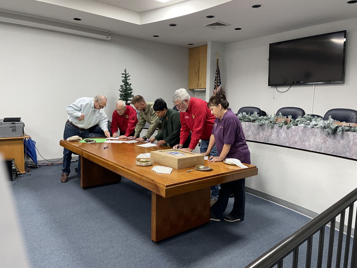 Council members signing paperwork