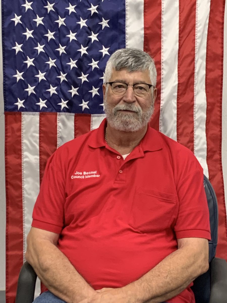 council member in front of American flag