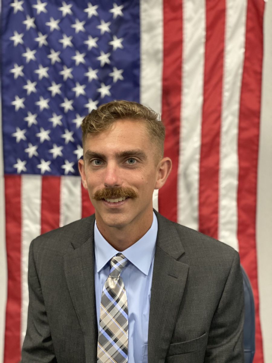 council member in front of American flag